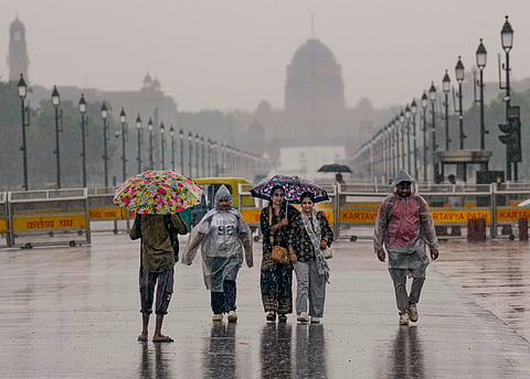 People walk along the Kartavya Path amid monsoon rain, in New Delhi, on Saturday | PTI