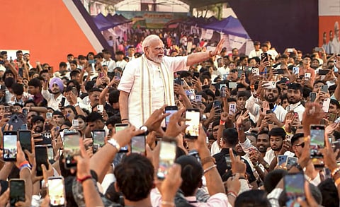 The PM acknowledges the crowd as he arrives during a programme for the inauguration and foundation stone laying of various development projects, in Vadodara, on Tuesday | PTI