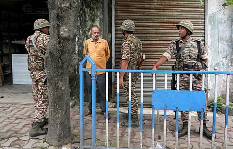 Security personnel interact with a man as they stand guard outside the office of TMC MP Nadimul Haque during an ED raid in connection with a money laundering investigation, in Kolkata | File image/PTI