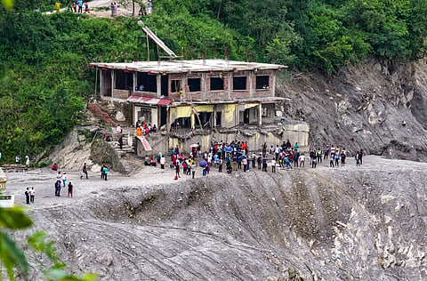 Locals inspect damage inside a structure filled with mud and debris along the Trishuli River, at Devighat, in Nuwakot district, Nepal | PTI