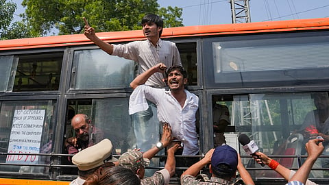 Demonstrators shout slogans from inside a police vehicle after being detained during a protest, in New Delhi, on Saturday | PTI 
