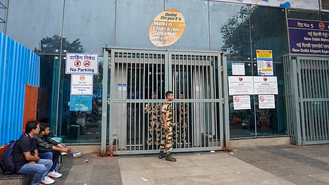 Security personnel stand guard outside the closed entry gates of New Delhi Metro station as heavy police deployment and entry restrictions are enforced, in New Delhi, on Saturday | PTI