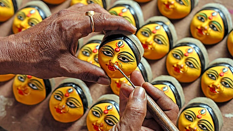 An artist paints on miniature clay idols of Goddess Durga ahead of the Durga Puja festival, in Birbhum, on Wednesday | PTI