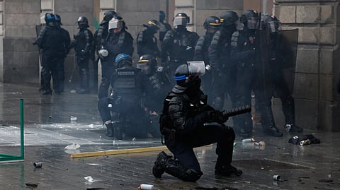 A police officer throws a teargas canister to a protesters after a demonstration against rising living costs in Rennes, France, on Saturday | PTI