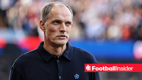 Thomas Tuchel in a polo shirt on sideline smiling and looking to the right
