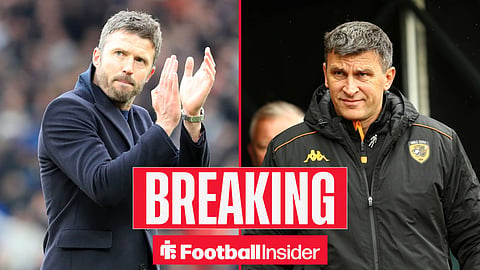 Manchester United manager Michael Carrick clapping his hands to the fans, alongside Hull City manager Sergej Jakirovic in a branded club coat.