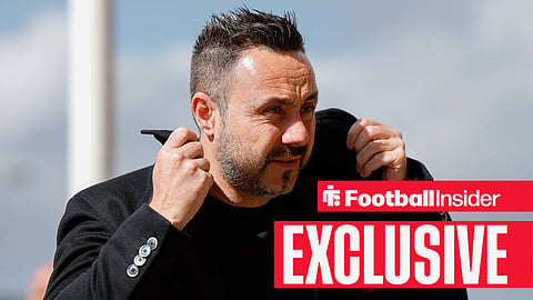 Tottenham manager Roberto De Zerbi adjusts his collar 