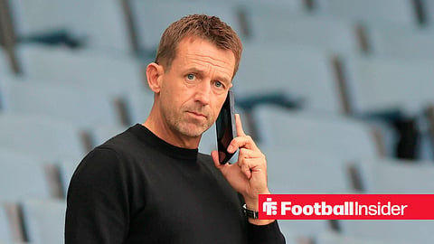 Neil McCann standing inside Hampden Park talking on his phone