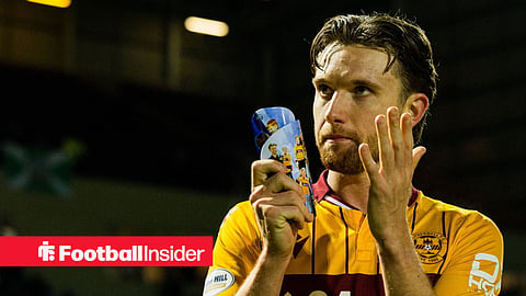 Elliot Watt clapping with shinpad in hand with Motherwell home kit on