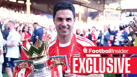 Arsenal manager Mikel Arteta smiles while holding the Premier League trophy
