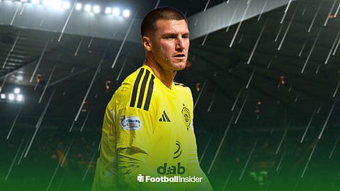 Celtic goalkeeper Sam Johnstone stands in the rain at Celtic Park.