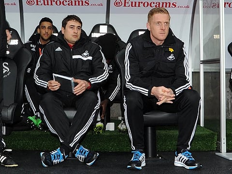 Swansea city's manager Garry Monk (c) with his coaching staff sits in dugout ahead of k/o. Barclays Premier league, Swansea city v Crystal Palace match at the Liberty Stadium in Swansea, South Wales on Sunday 2nd March 2014.
pic by Andrew Orchard, Andrew Orchard sports photography.
contact and payments to Andrew Orchard, 2 Old Vicarage close, Pengam, Blackwood, Gwent. NP12 3TU. Tel 07974 069129.  vat reg no 615 9784 04,  
no unpaid use, All usage chargeable. if self billing, bacs to  20 10 26,  20034991,  Barclays