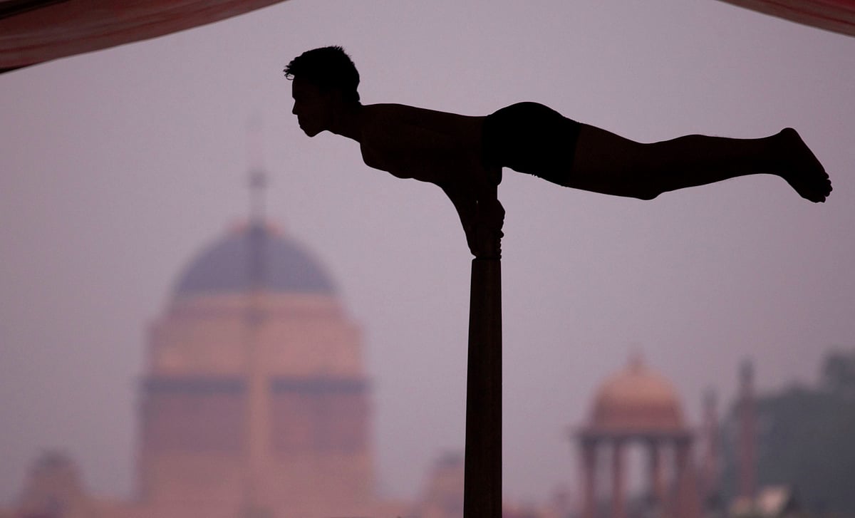 A yoga enthusiast performs Mallakhamba during a mass yoga session organised to mark the 5th International Day of Yoga, at Rajpath in New Delhi.