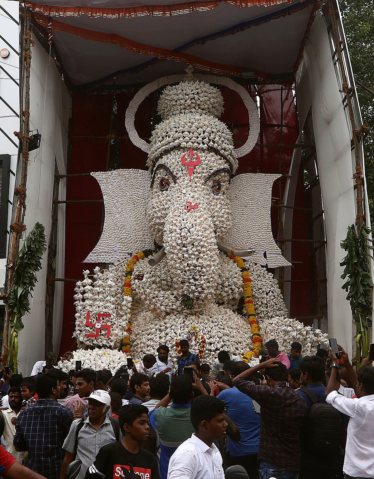 People take photos of Ganesha idol which made of conch shell on the occasion of Ganesh Chaturthi festival at Valampuri