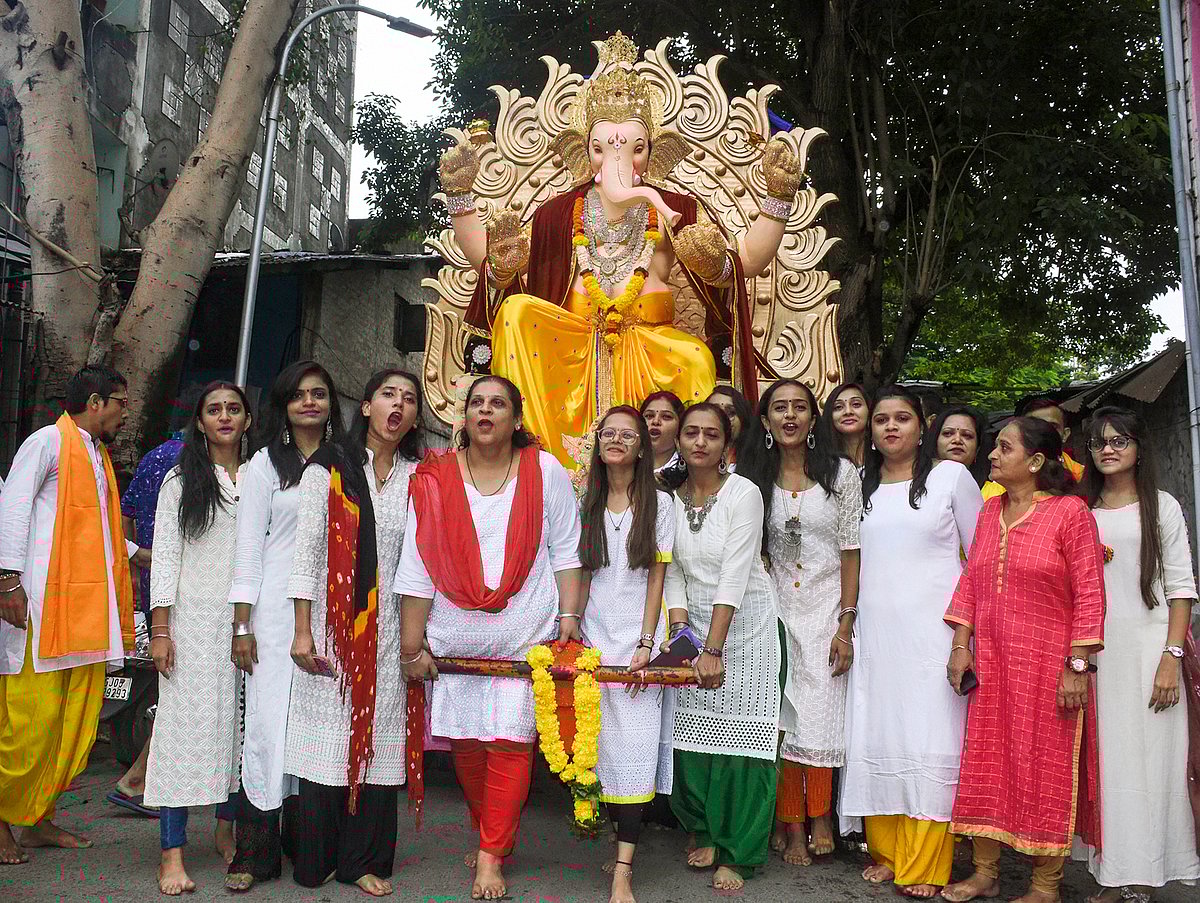 Devotees carry an idol of Lord Ganesha on the occasion of Ganesh Chaturthi festival, in Surat