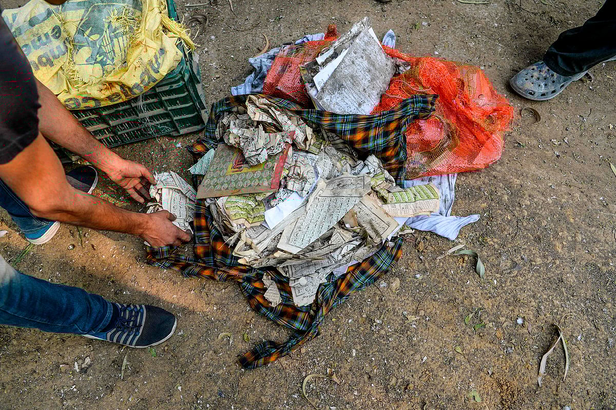 People prepare to bury copies of the Koran after they recovered from a burnt-out mosque following clashes between people supporting and opposing a contentious amendment to India's citizenship law, in New Delhi on February 26, 2020.
