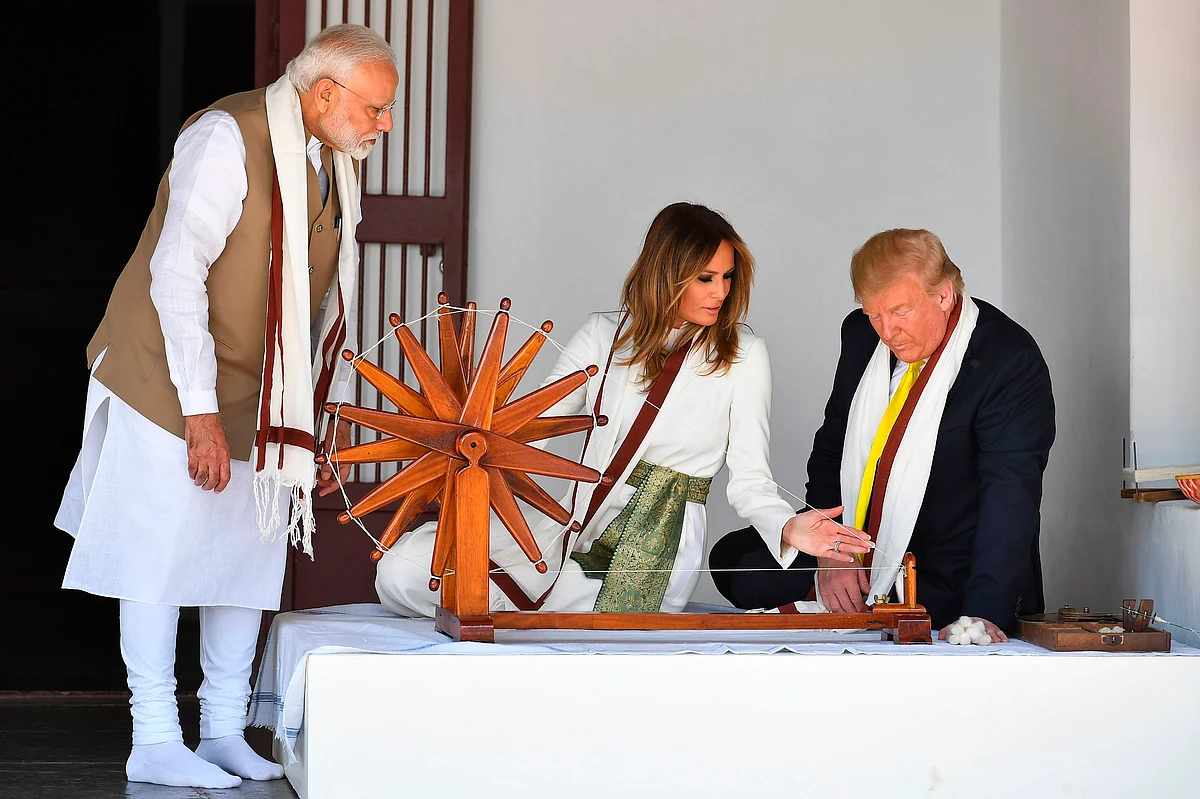 US President Donald Trump (R) and First Lady Melania Trump sit next to a charkha, or spinning wheel, as India's Prime Minister Narendra Modi (L) looks on during their visit at Gandhi Ashram in Ahmedabad on February 24, 2020.