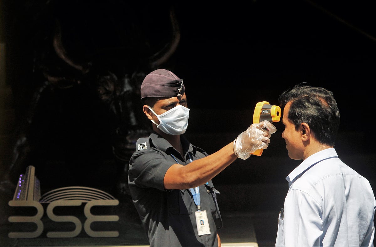 Thermometer guns are used by the security personnel to check the temperature of the visitors outside the Bombay Stock Exchange, in Mumbai on Monday.