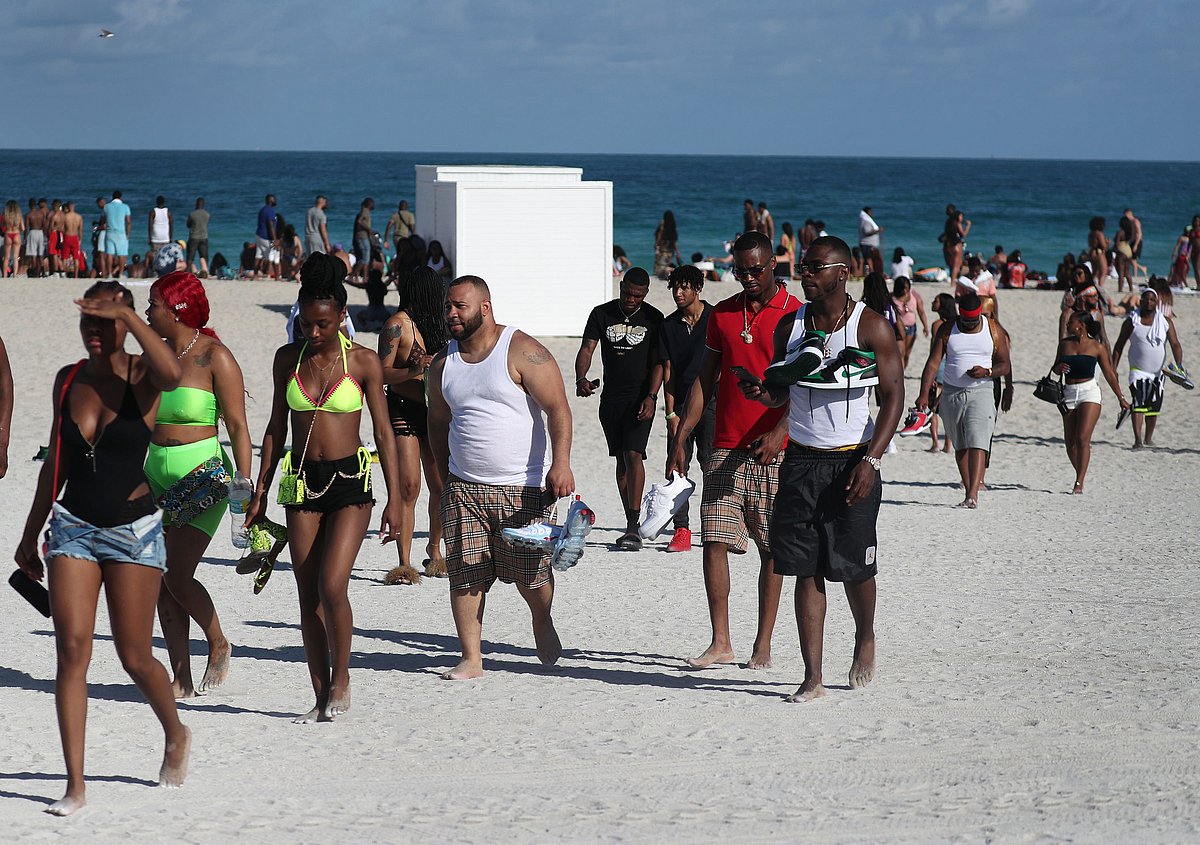 Tourists relax on the beach in Miami Beach, Florida.