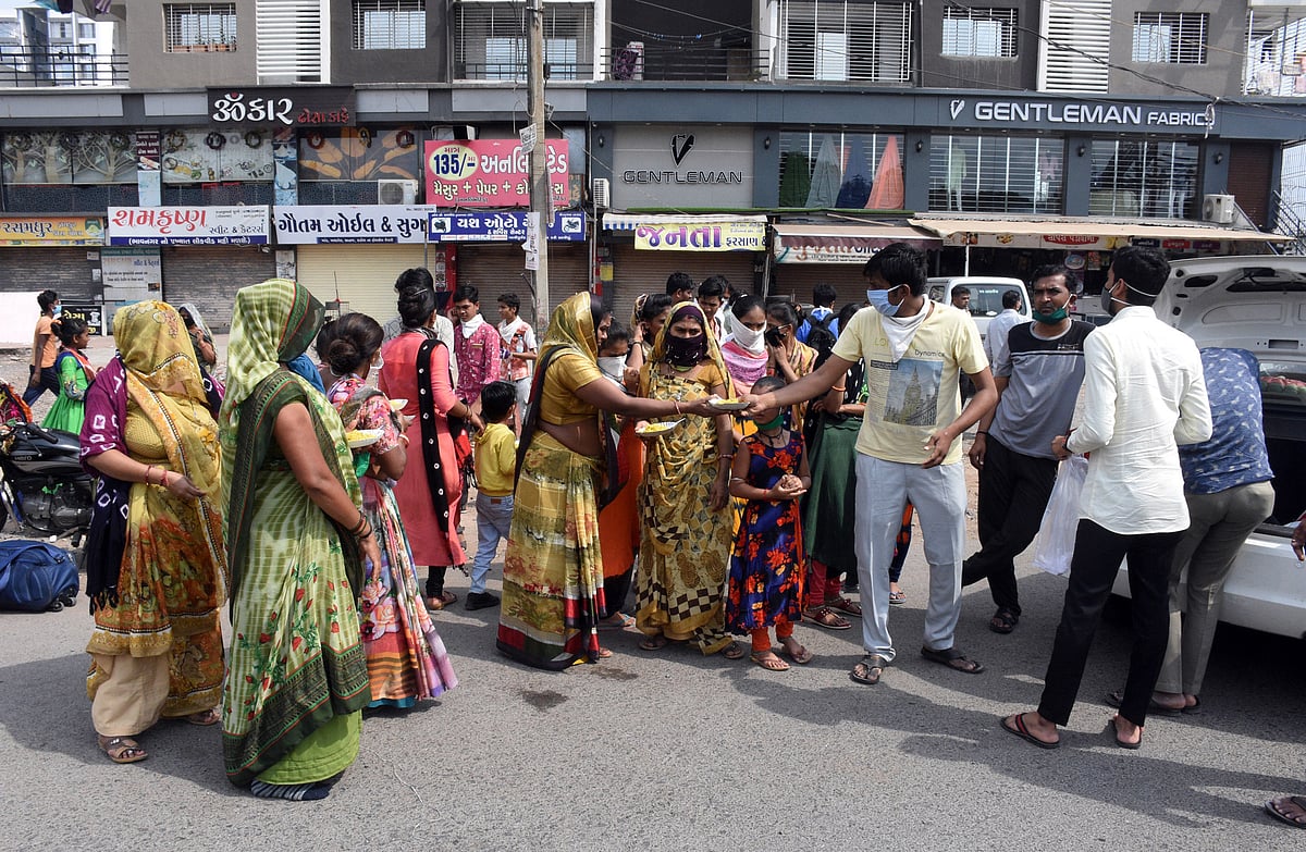 Migrant labourers walk the distance as they didn't find any transport facility on the second day of the lockdown announced for the entire country in Surat on Thursday.