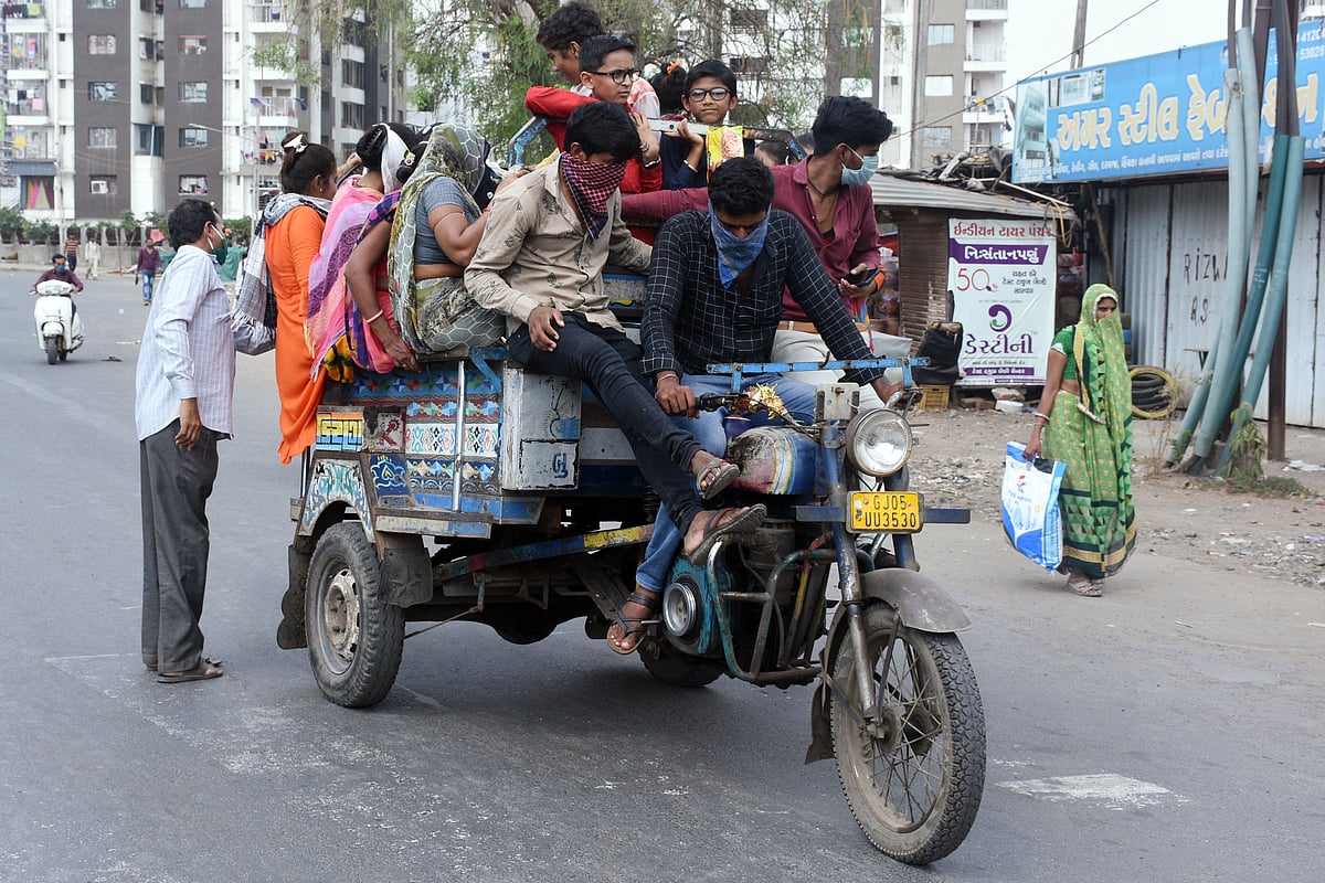 Migrant labourers on board a three wheeler transport rickshaw as they leave for their respective villages on the second day of the lockdown announced for the entire country in Surat on Thursday.