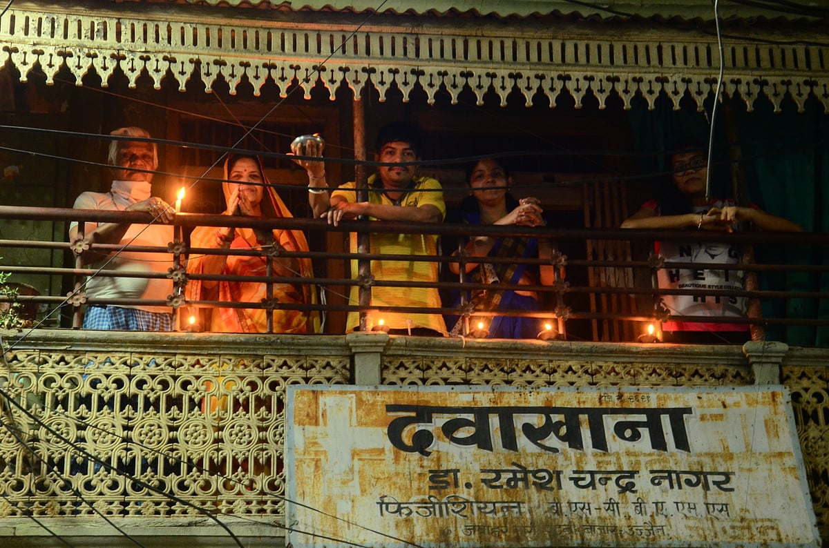 A couple along with their parents lighting the diyas and candles from their balcony at Patni Bazaar area. 
