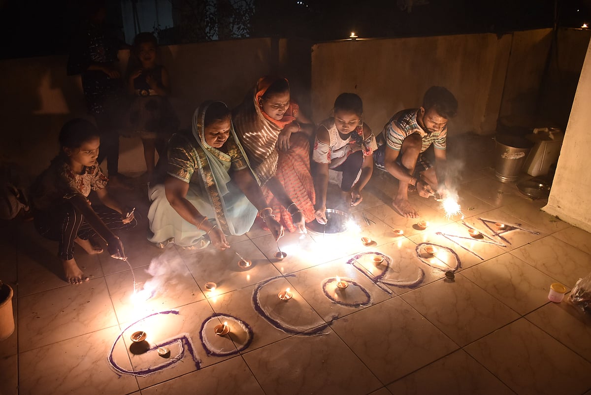 Members of a three generation: grandmother, daughter-in-law and granddaughters light diyas depicting ‘Go Corona’ message on the terrace of their house at Dr Pathak Ki Chawl, Nizatpura.  