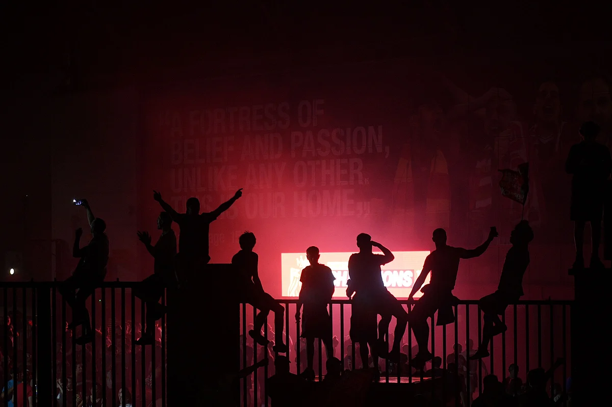 Fans celebrating Liverpool winning the Premier League title outside Anfield stadium in Liverpool, north west England.