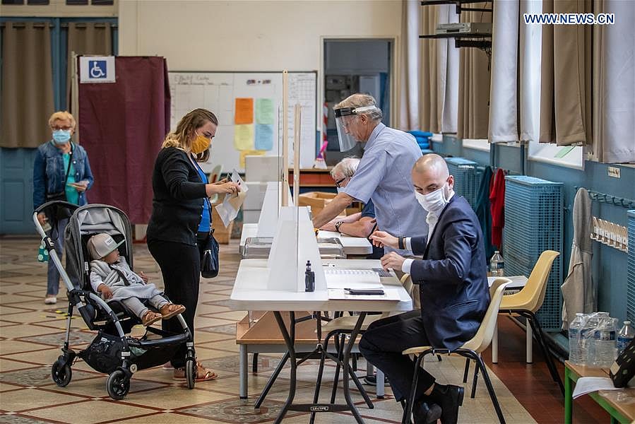 People wearing protective masks prepare to vote at a polling station during the second round of municipal elections in Paris, France, June 28, 2020. 