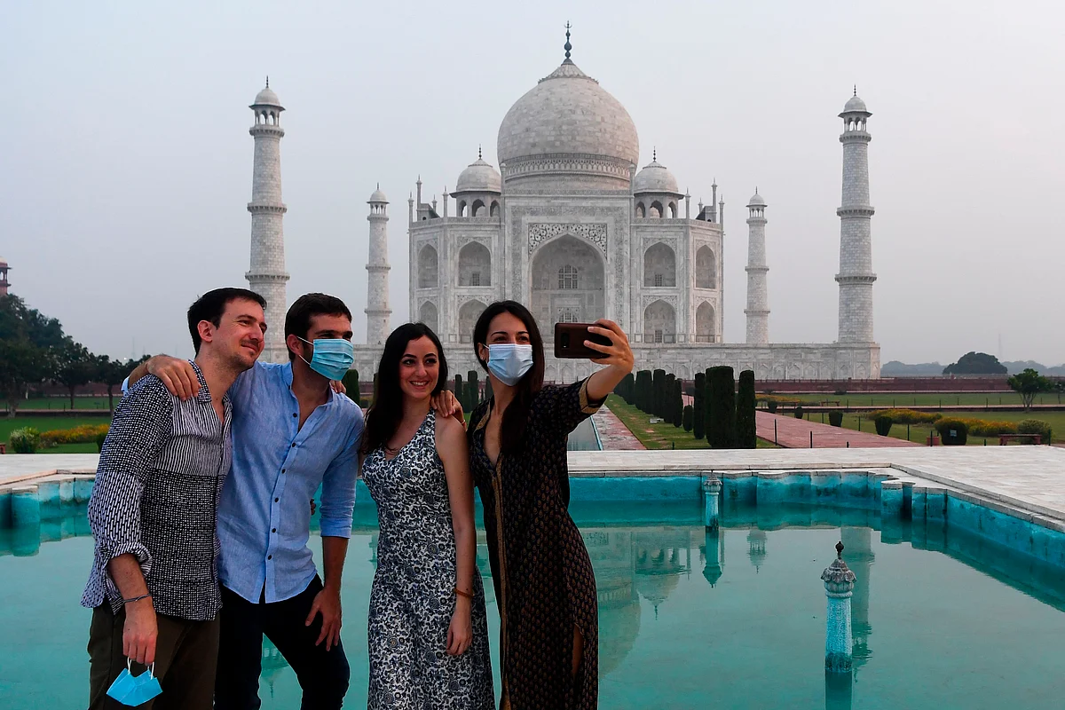 Tourists have their pictures taken at the Taj Mahal in Agra on September 21, 2020. - The Taj Mahal reopens to visitors on September 21 in a symbolic business-as-usual gesture, even as India looks set to overtake the US as the global leader in coronavirus infections.