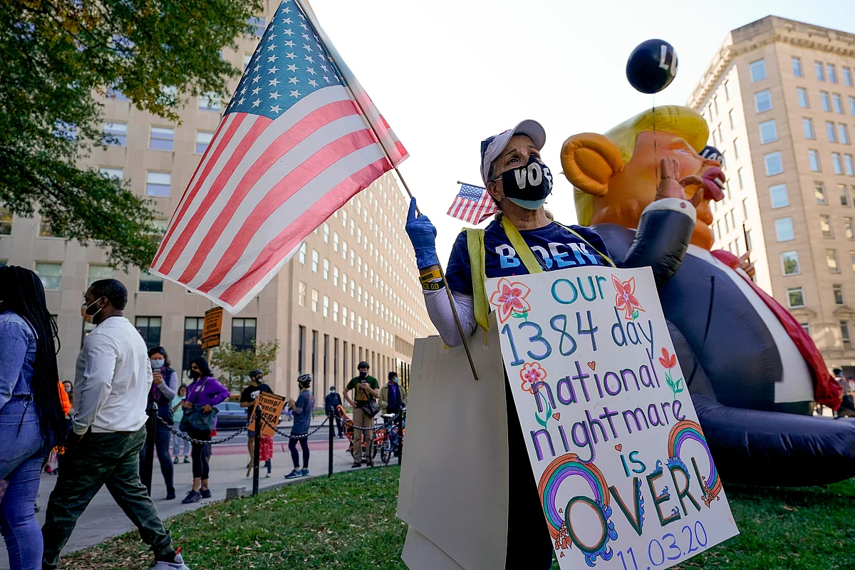 A woman at McPherson Square reacts as CNN announces that Democratic presidential candidate Joe Biden has defeated Pres. Donald Trump to become the 46th President of the United States, Saturday, Nov. 7, 2020, in Washington