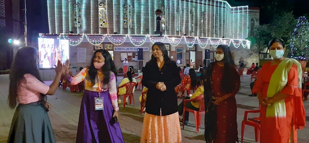 The bright lights of Christmas brought bright smiles to faces of community members. A group of women greet each other after the Holy Mass.
