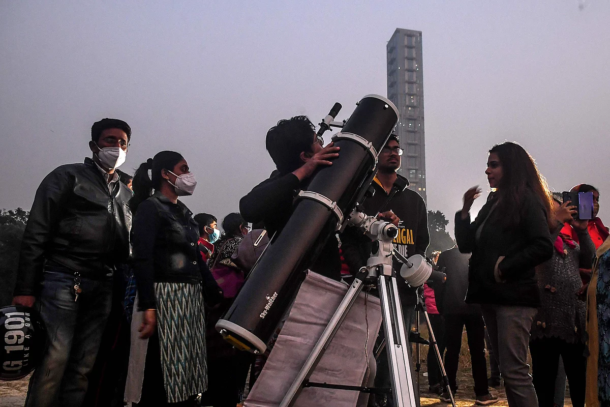 People stand in a queue to see a great conjunction of Jupiter and Saturn at the Maidan area in Kolkata on December 21, 2020.