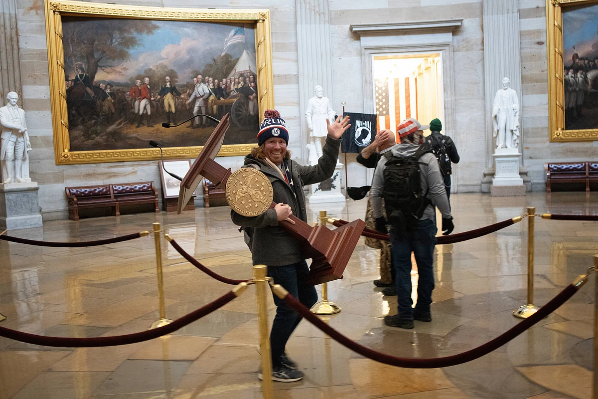 A pro-Trump protester carries the lectern of U.S. Speaker of the House Nancy Pelosi through the Roturnda of the U.S. Capitol Building