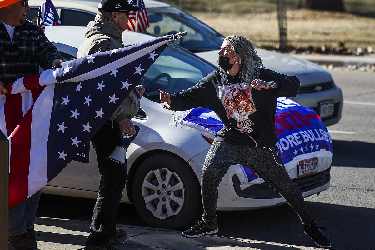 A driver, right, exits her car and attacks a Donald Trump supporter, left, next to the Colorado State Capitol after the supporter started to write on her vehicle window on January 6, 2021 in Denver, Colorado.
