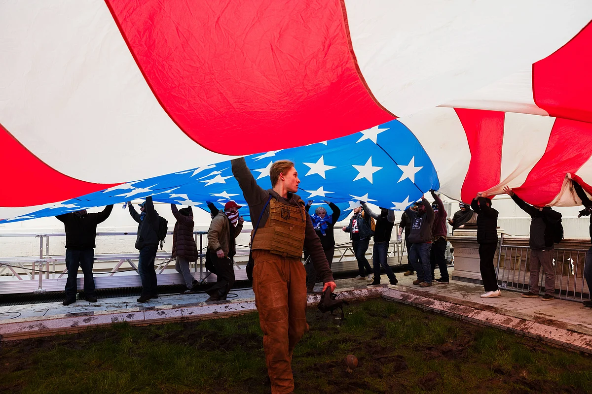 A group of pro-Trump protesters raise a giant America Flag on the West grounds of the Capitol Building on January 6, 2021 in Washington, DC.