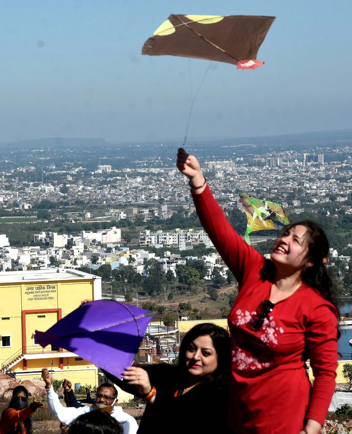 Women join kite festival at Manua Bhan ki Tekri on Makar Sankranti on Thursday.