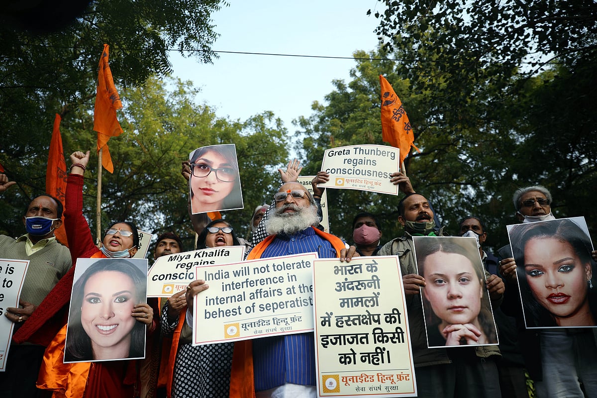 Members of United Hindu Front hold placards of international celebrities who lent their support to farmers protest, in New Delhi on Thursday. 
