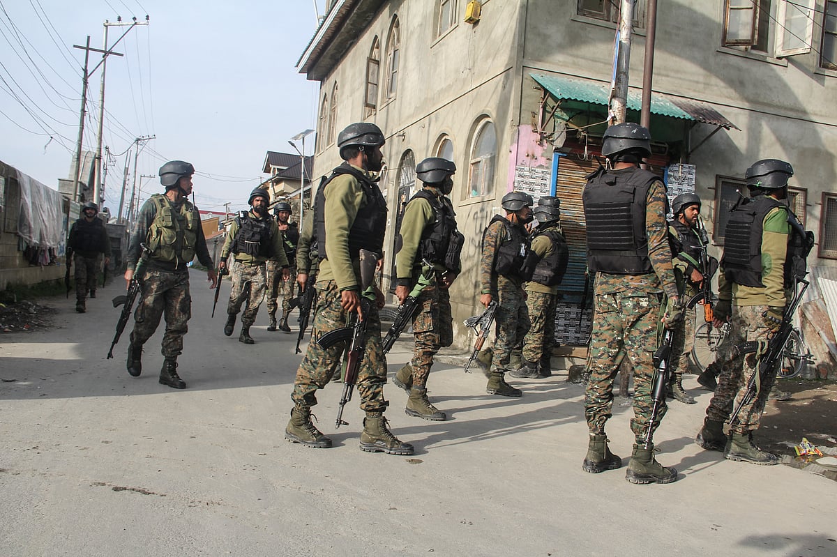Paramilitary soldiers inspect the spot of militants attack in Lawaypora on the outskirts of Srinagar.