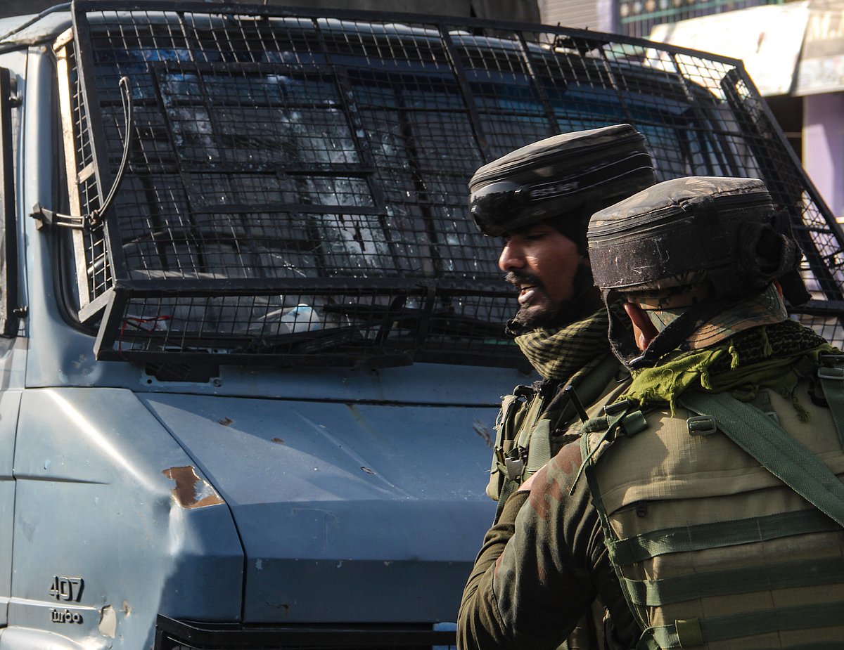 Security personnel inspect the vehicle which was attacked by militants in Lawaypora on the outskirts of Srinagar.