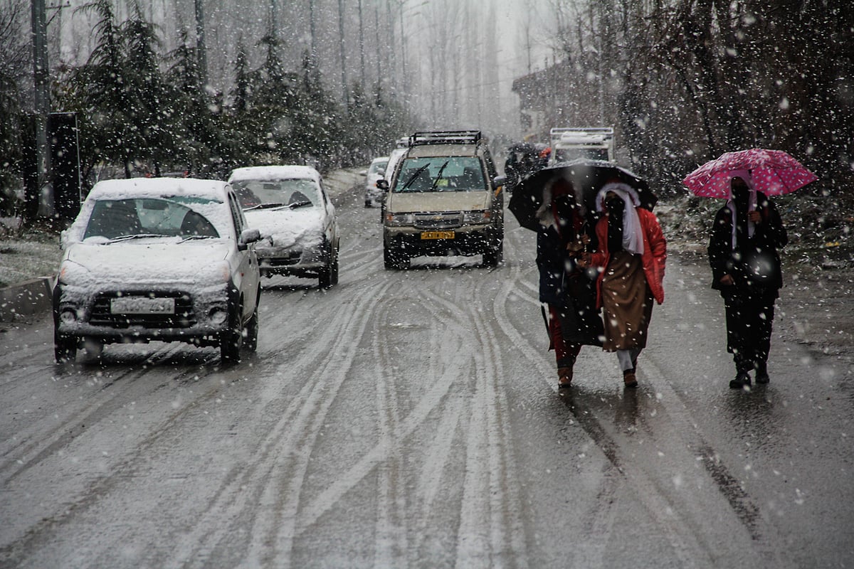 Vehicles moves along a road amid snowfall on March 08, 2021 in parts of Kashmir