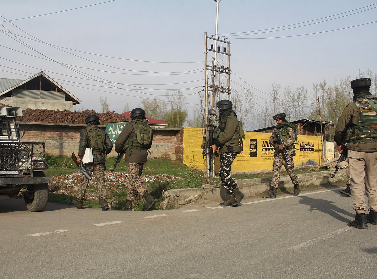 Paramilitary soldiers inspect the spot of militants attack in Lawaypora on the outskirts of Srinagar.