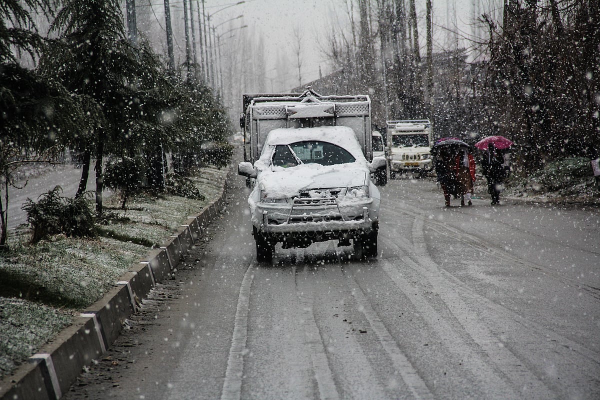 Vehicles moves along a road amid snowfall on March 08, 2021 in parts of Kashmir