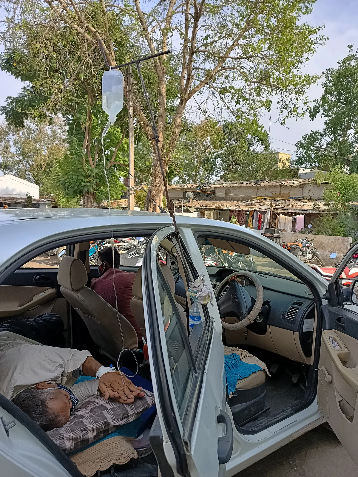 Patient getting treatment in a car outside Sardarpur CHC on Sunday.