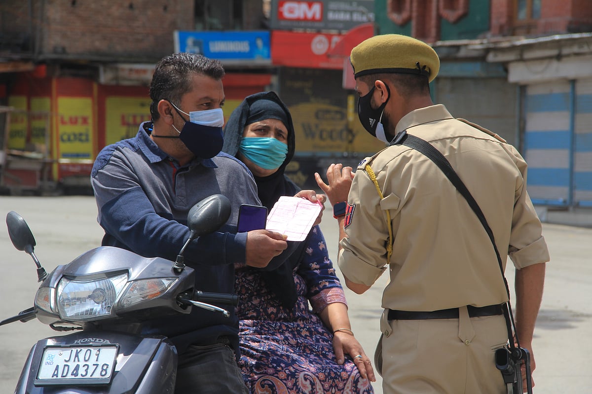Policeman checks the curfew pass of a civilian during strict restrictions imposed on the death anniversaries of two separatists leaders Mirwaiz Mohammed Farooq and Abdul Ghani Lone, in Srinagar, Kashmir on May 21, 2021.