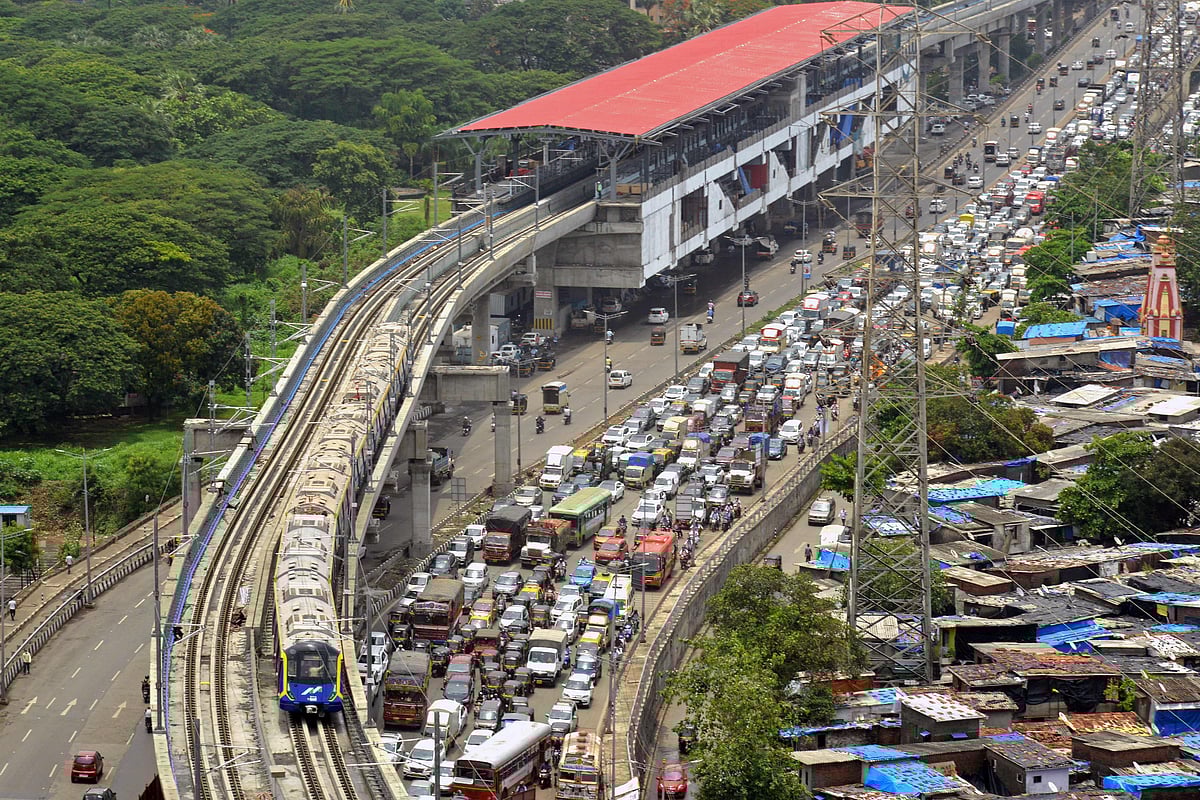 A metro train passes through a residential area during its first official safety trial run on a new line in Mumbai on May 31, 2021.