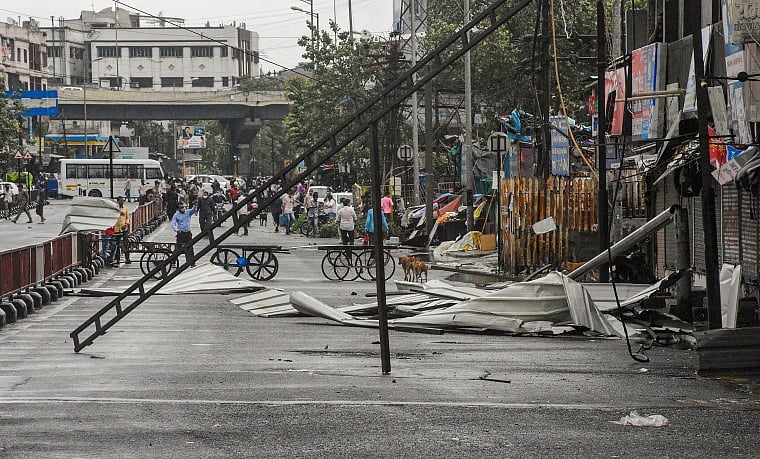 Tin sheets lie on a road after being detached from the roofs of a few shops due to strong winds, induced by Cyclone Tauktae in Surat