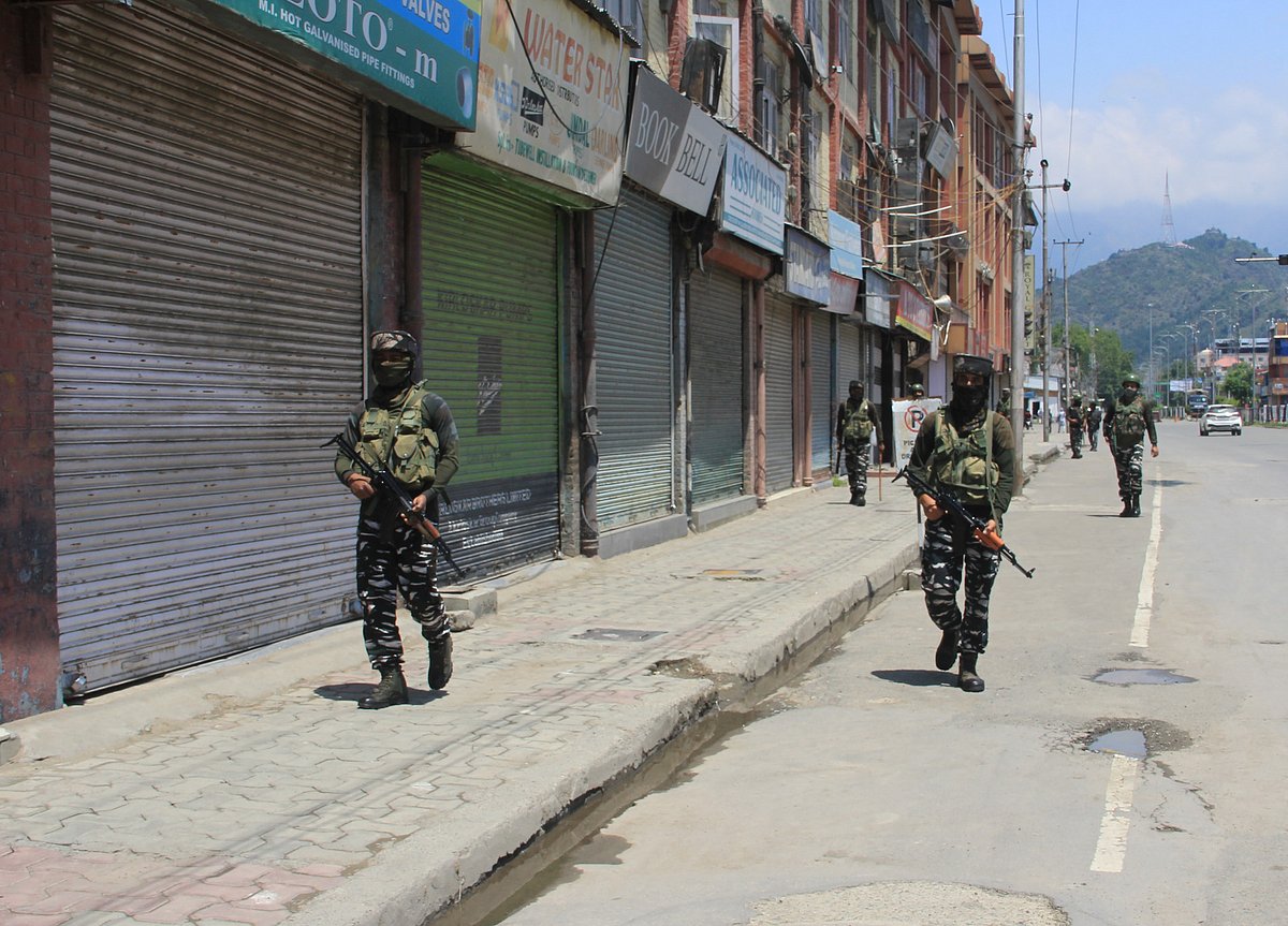 Paramilitary troopers stand alert at a closed market during strict restrictions imposed on the anniversaries of two separatist leaders Mirwaiz Mohammad Farooq and Abdul Ghani Lone, in Srinagar, Kashmir on May 21, 2021.