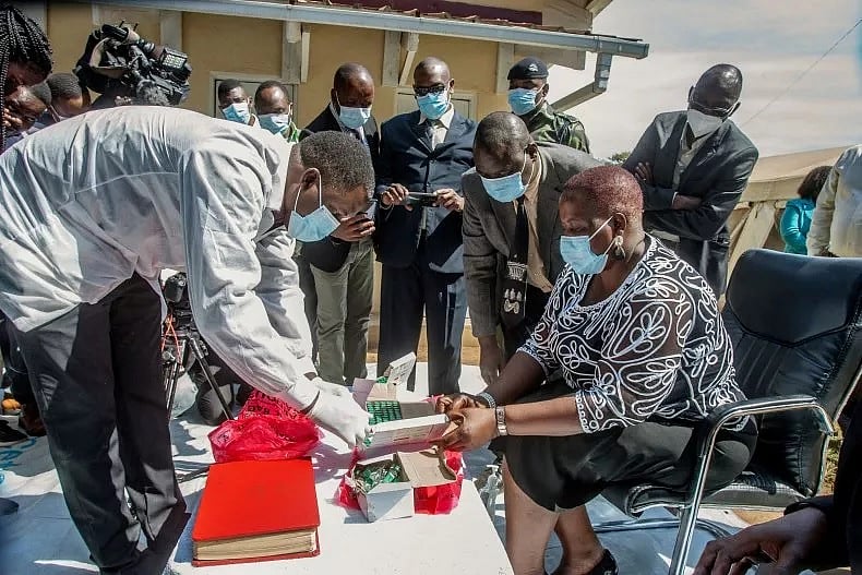 A pharmaceutical expert (L) opens a pack of expired COVID-19 Astra Zeneca vaccines to show to Malawi’s Health Minister Khumbize Kandodo Chiponda (R) before they are destroyed in a furnace at a pharmaceutical incinerator at Kamuzu Central Hospital in Lilongwe on May 19, 2021