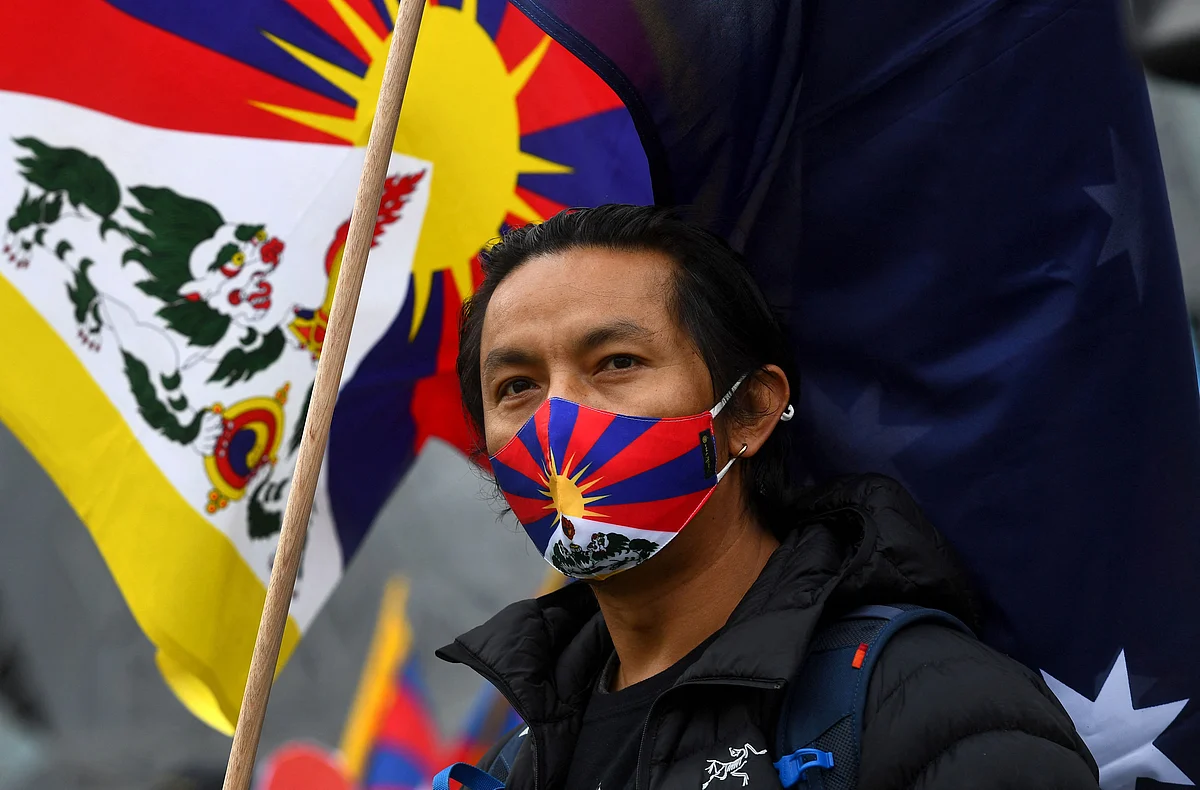 An activist stands with the Tibetan flag as he joins a protest by members the local Hong Kong, Tibetan and Uyghur communities in Melbourne on June 23, 2021, calling on the Australian government to boycott the 2022 Beijing Winter Olympics over China's human rights record.